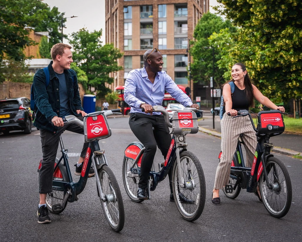 Three people riding around London on Santander Cycles for free