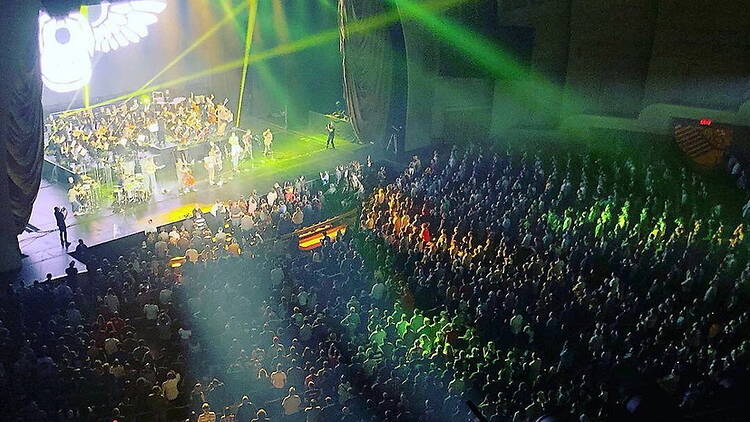 Wide shot view of a performance on a stage in front of a large crowd. Wide shot view of a performance on a stage in front of a large crowd.