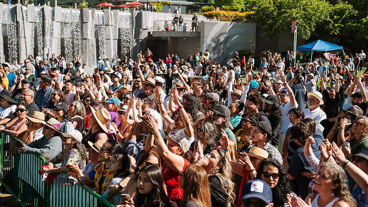 Wide shot view of a crowd cheering at an outdoor event. Wide shot view of a crowd cheering at an outdoor event.