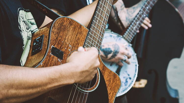 Close-up view of hands strumming stringed musical instruments. Close-up view of hands strumming stringed musical instruments.