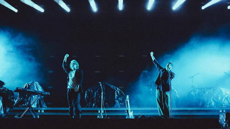 Wide shot view of musicians performing under stage lights at a live concert.