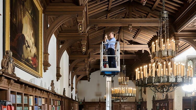 Wide shot view of person working on lift inside library. Wide shot view of person working on lift inside library.
