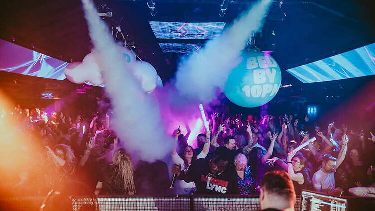 A wide shot of a crowd dancing at a nightclub A wide shot of a crowd dancing at a nightclub