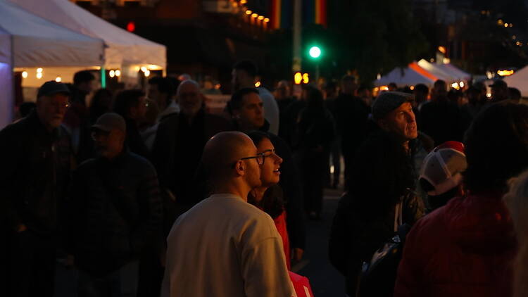 A wide shot of people browsing a night market A wide shot of people browsing a night market