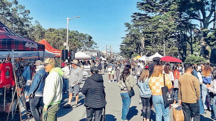 A wide shot of people browsing an outdoor market A wide shot of people browsing an outdoor market