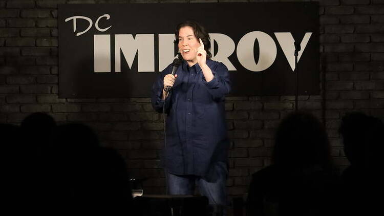 Wide shot view of a person talking in comedy stage.