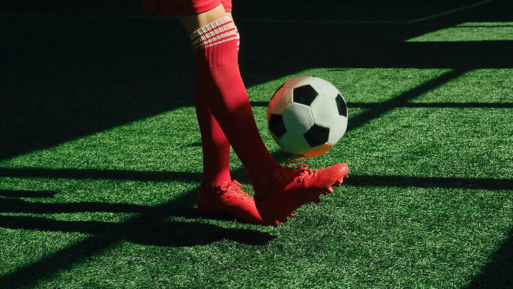 A close-up of a soccer player controlling a ball on a grassy field. A close-up of a soccer player controlling a ball on a grassy field.