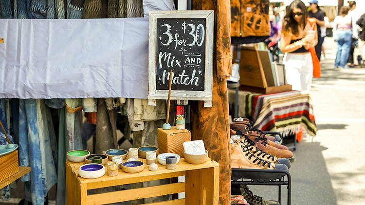 A close-up of clothing, shoes and handmade items displayed at an outdoor market. A close-up of clothing, shoes and handmade items displayed at an outdoor market.