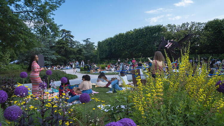 Wide shot of people relaxing in a flower garden. Wide shot of people relaxing in a flower garden.