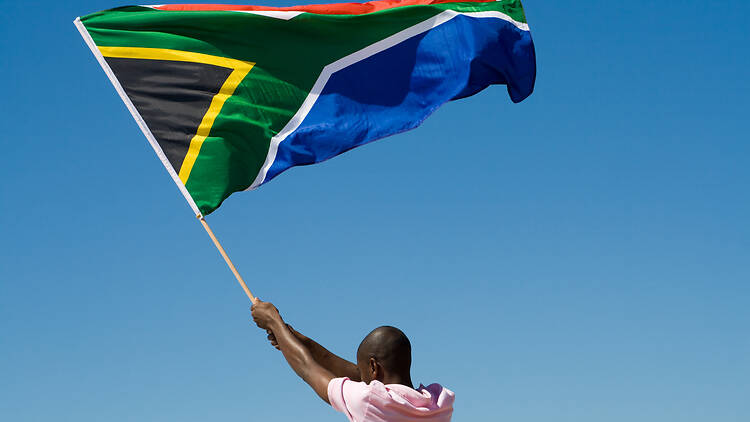Man waving South African flag Rear view of a man waving South African flag in clear sky