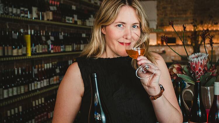 woman smiles and sniffs glass of wine