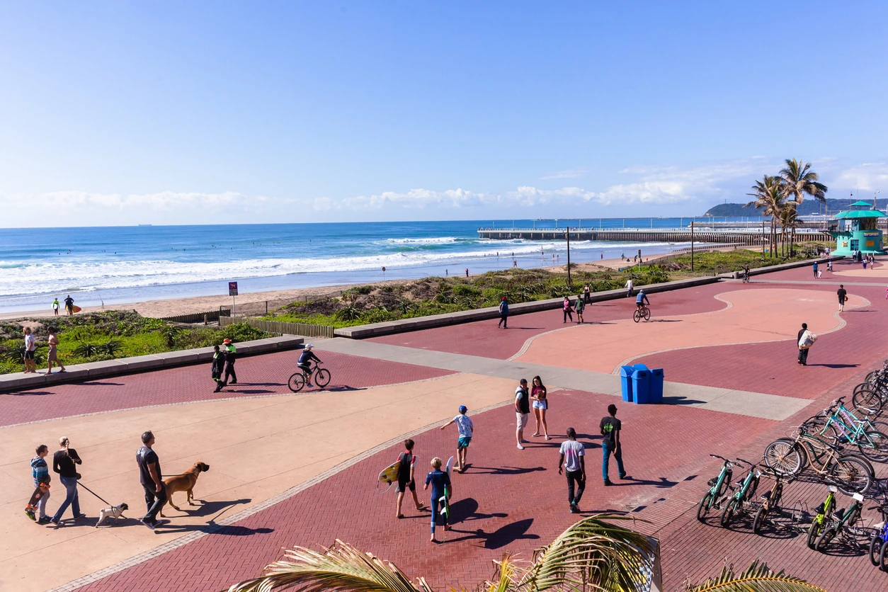 Durban beach front promenade ocean waves surfers piers cycling people lifestyle landscape.