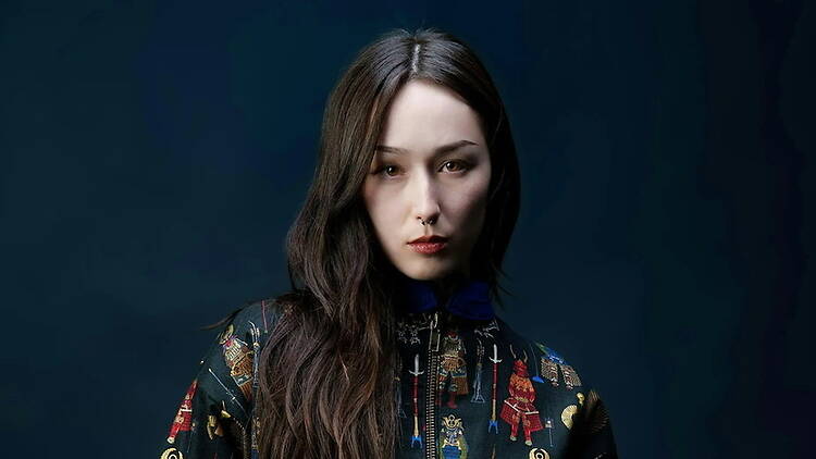Close-up of a person posing against a dark studio background. Close-up of a person posing against a dark studio background.