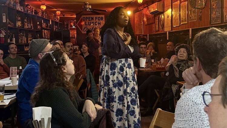 Wide view of performer speaking in a crowded restaurant. Wide view of performer speaking in a crowded restaurant.