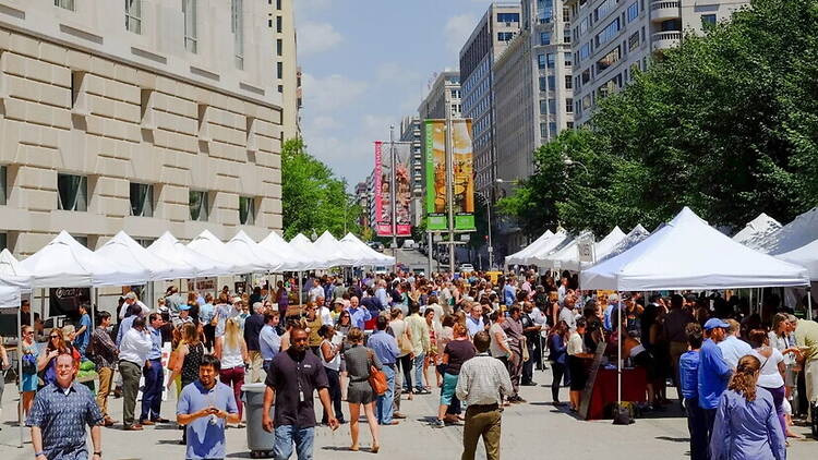 Wide view of people walking through an outdoor street market. Wide view of people walking through an outdoor street market.