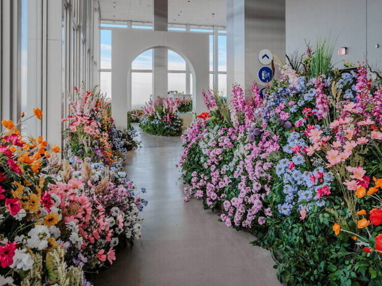 A wide shot of colorful flower displays lining an indoor hallway A wide shot of colorful flower displays lining an indoor hallway