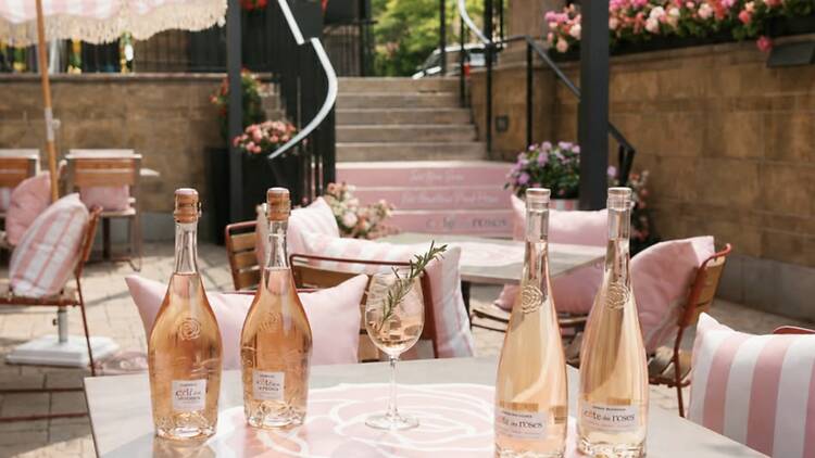 A close-up of bottles and a glass displayed on an outdoor table. A close-up of bottles and a glass displayed on an outdoor table.