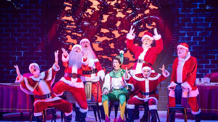 Elf the Musical many people playing the role of Santa with one elf