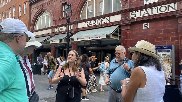 Tour guide leading a group outside Covent Garden Station Tour guide leading a group outside Covent Garden Station