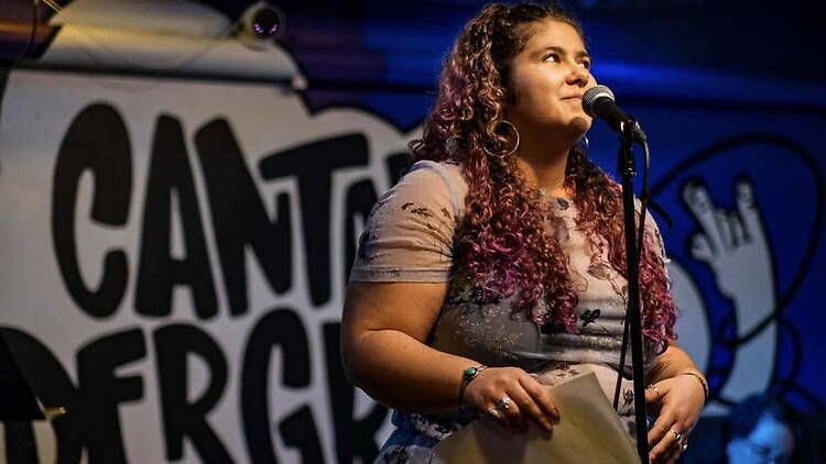 A close-up of a person speaking into a microphone on a stage. A close-up of a person speaking into a microphone on a stage.