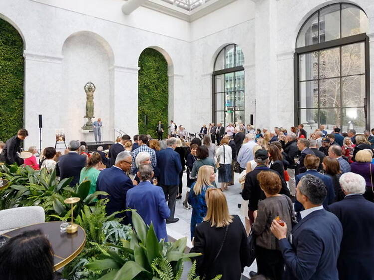 Wide view of attendees gathering at an indoor event venue. Wide view of attendees gathering at an indoor event venue.
