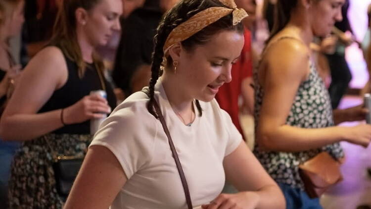 A close-up of a person dancing at an indoor live event. A close-up of a person dancing at an indoor live event.