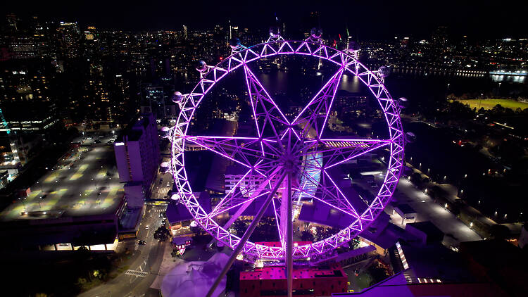 Melbourne Star The Melbourne Star illuminated in purple lights at night.