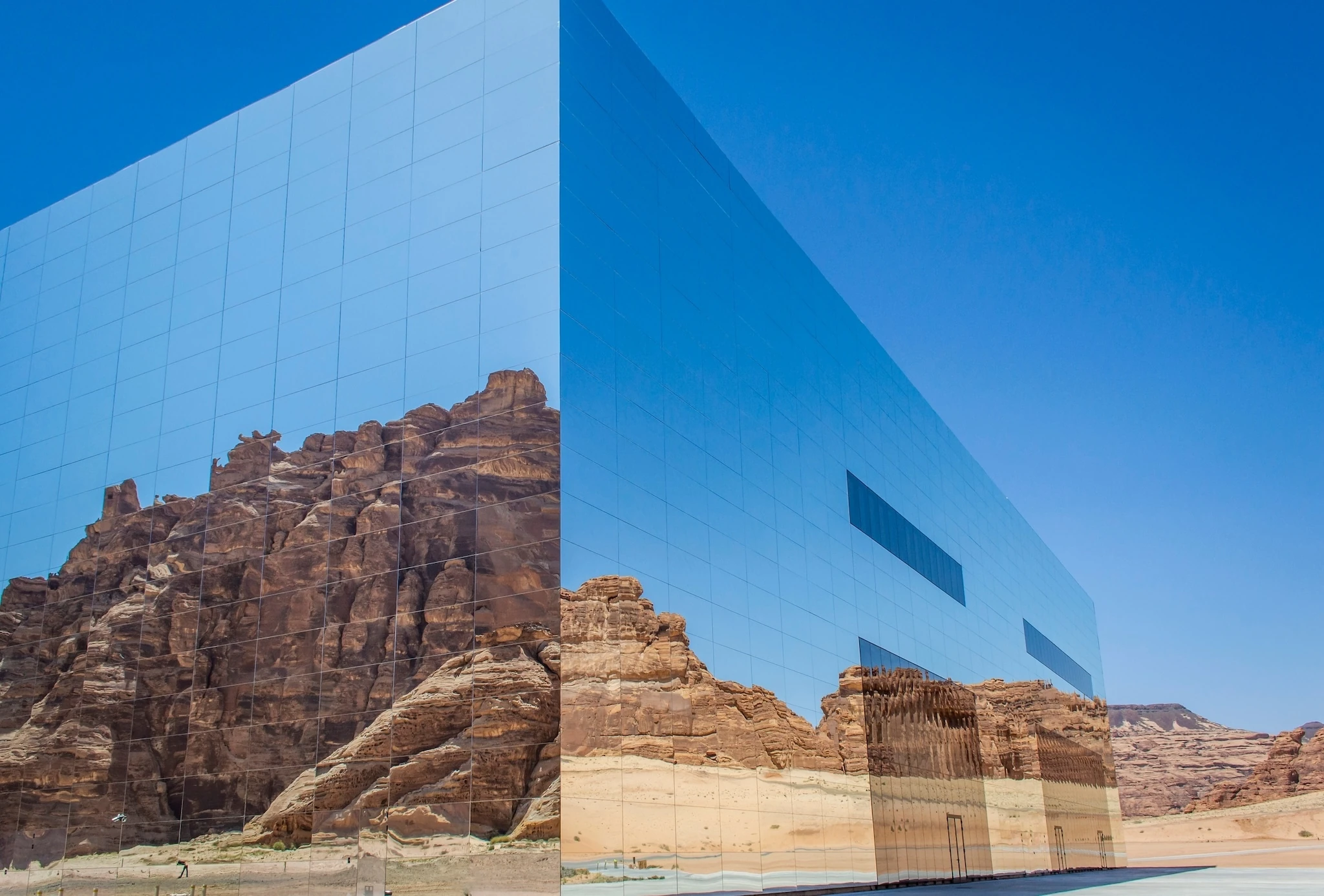 External view of Maraya building with reflection of rock mountains and blue sky in the mirrored wall