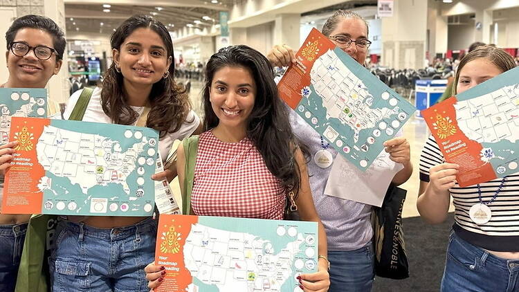A close-up of attendees holding event maps at a convention center. A close-up of attendees holding event maps at a convention center.