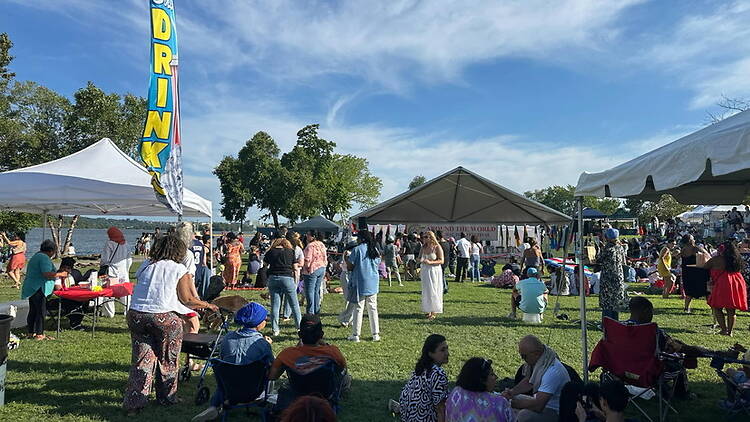 A wide shot of people enjoying activities at an outdoor community festival. A wide shot of people enjoying activities at an outdoor community festival.