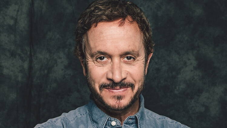 Close-up of a smiling man looking at the camera against a dark studio backdrop. Close-up of a smiling man looking at the camera against a dark studio backdrop.
