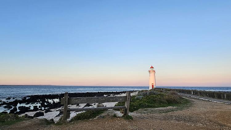 A light house sitting on top of a sandy beach