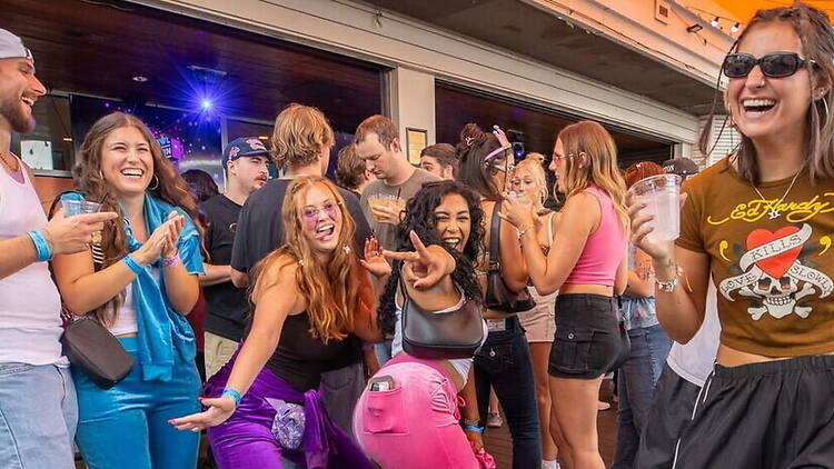 A wide shot of people socializing outside a lively venue. A wide shot of people socializing outside a lively venue.