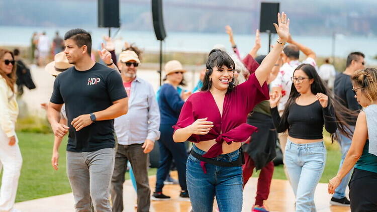 A wide shot of people dancing at an outdoor event