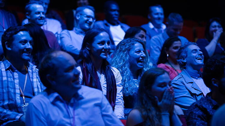 A wide shot of attendees laughing during an indoor event