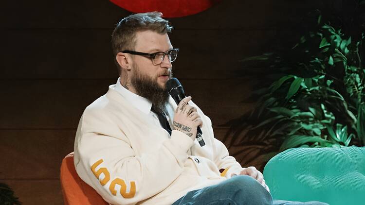 A person speaking into a microphone on a stage