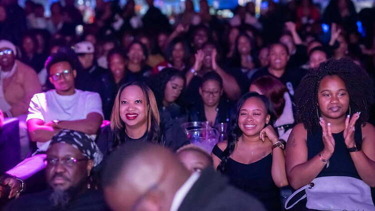 Wide view of audience watching a live performance at an indoor venue. Wide view of audience watching a live performance at an indoor venue.