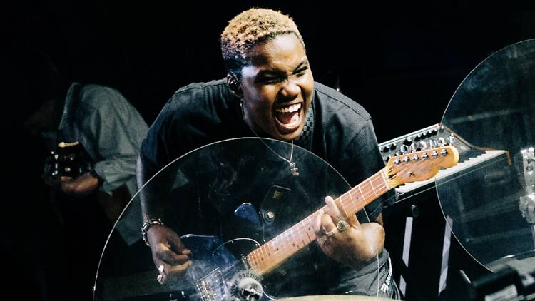 A close-up of a person playing an electric guitar on a stage A close-up of a person playing an electric guitar on a stage