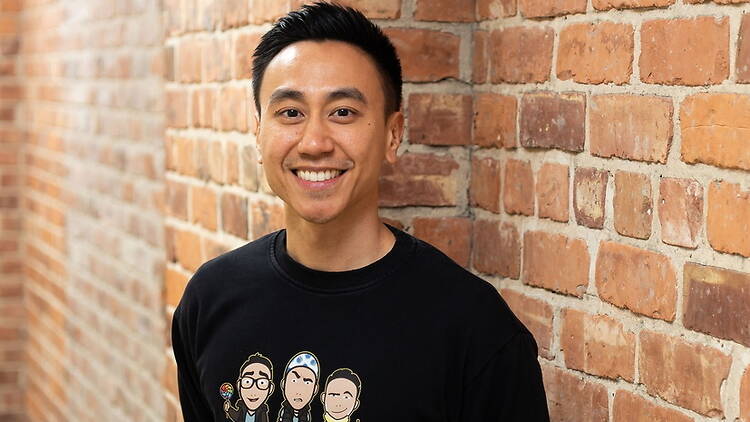 A person smiling in front of a brick wall A person smiling in front of a brick wall
