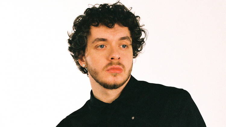 A close-up of a person looking to the side against a plain studio background. A close-up of a person looking to the side against a plain studio background.