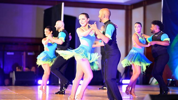 A wide shot of dance couples performing on a ballroom stage A wide shot of dance couples performing on a ballroom stage