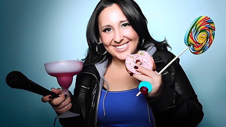 A close-up of a person holding a microphone, drink, donut and lollipop against a blue background. A close-up of a person holding a microphone, drink, donut and lollipop against a blue background.