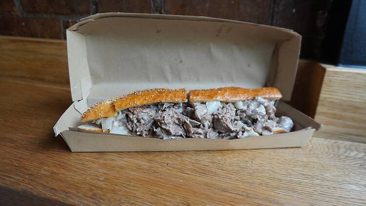 Philly cheesesteak sandwich in a carboard box