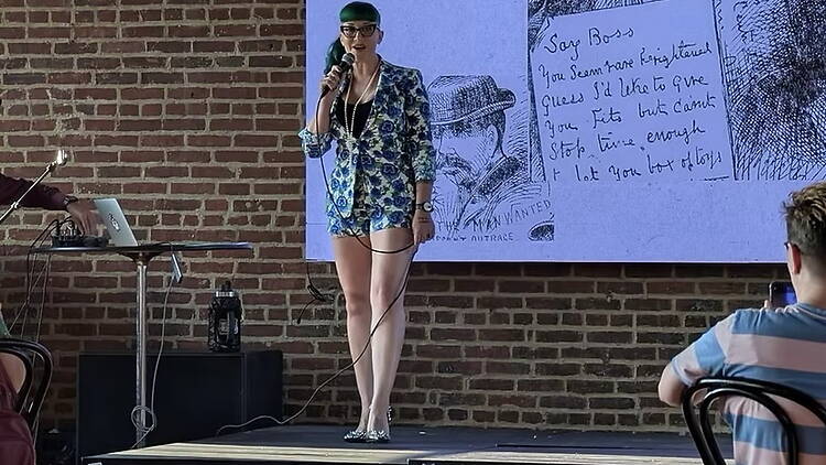 A wide shot of a speaker presenting on stage at an indoor event. A wide shot of a speaker presenting on stage at an indoor event.