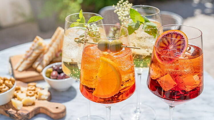 A close-up of colorful drinks served on a table with appetizers. A close-up of colorful drinks served on a table with appetizers.