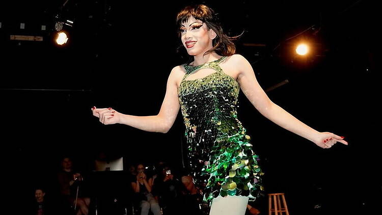 A wide shot of a performer dancing on stage under spotlights. A wide shot of a performer dancing on stage under spotlights.
