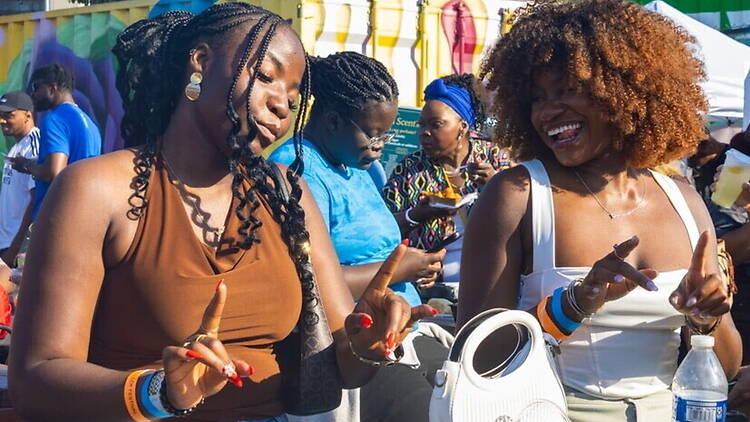 Close-up of two women dancing at an outdoor festival. Close-up of two women dancing at an outdoor festival.