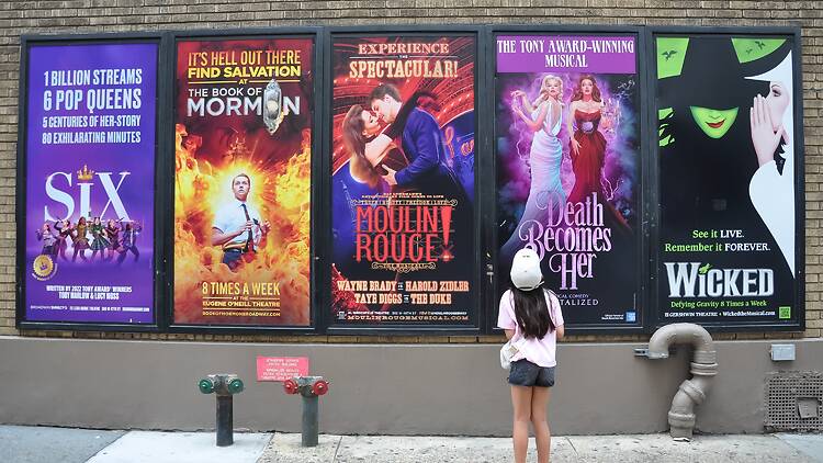 Young theater fan looking at Broadway ads