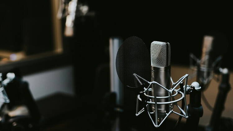 A close-up of a microphone on a stand in a recording studio. A close-up of a microphone on a stand in a recording studio.