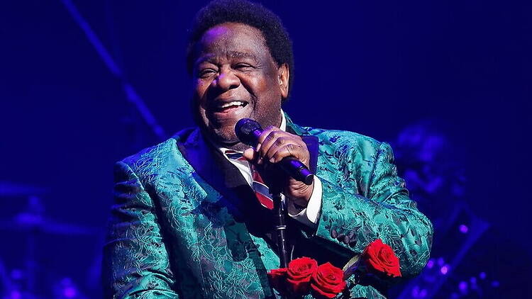 A close-up of a performer singing into a microphone on a stage. A close-up of a performer singing into a microphone on a stage.